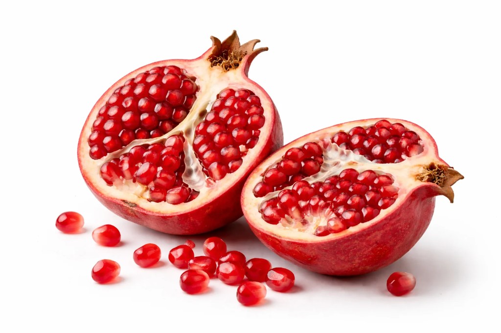 Freshly cut pomegranate halves with juicy arils on a white background